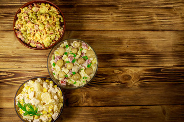 Set of festive mayonnaise salads on wooden table. Top view, copy space