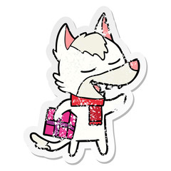 distressed sticker of a cartoon wolf with christmas present laughing