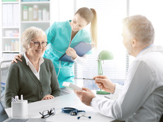 Professional doctor giving a prescription medicine to a senior patient