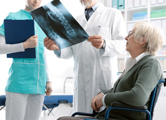 Fototapeta premium Doctor checking a senior patient's x-ray image