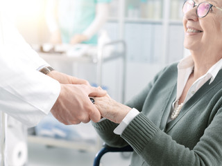 Professional doctor holding a senior patient's hands