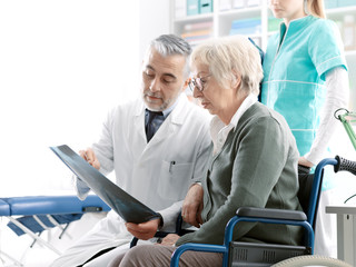 Radiologist checking an x-ray image with a senior patient