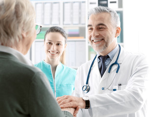 Professional doctor holding a senior patient's hands