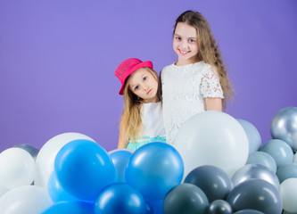 Fototapeta na wymiar Balloon birthday party. Girls little siblings near air balloons. Birthday party. Happiness and cheerful moments. Carefree childhood. Start this party. Sisters organize home party. Having fun concept