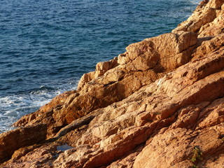 Rötliche Felsen an der Costa Brava mit blauem Meer