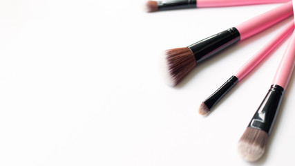 Obraz premium Set of makeup pink brushes on white background. Top view point, flat lay