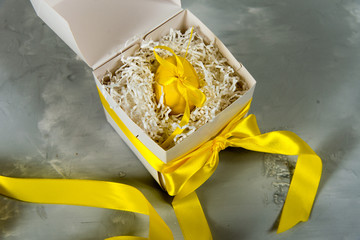 Holiday Easter. Yellow Easter egg in a gift box. Pascal egg decorated with turmeric.