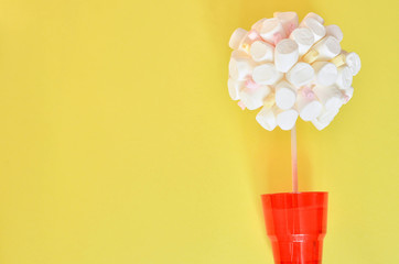 Tree made of marshmallows on colorful yellow background