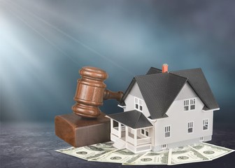 Wooden judge gavel and toy  house on  background