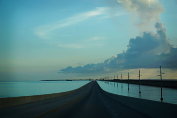 The road that leads to Key West from Miami with the ocean on both sides at dusk.