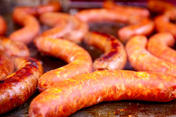 Baking delicious juicy sausages on barbecue plate