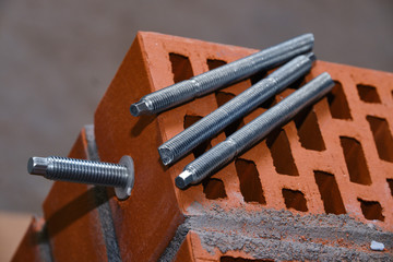 set of parts for mounting anchors in hollow brick and concrete lie on the surface of the brickwork...