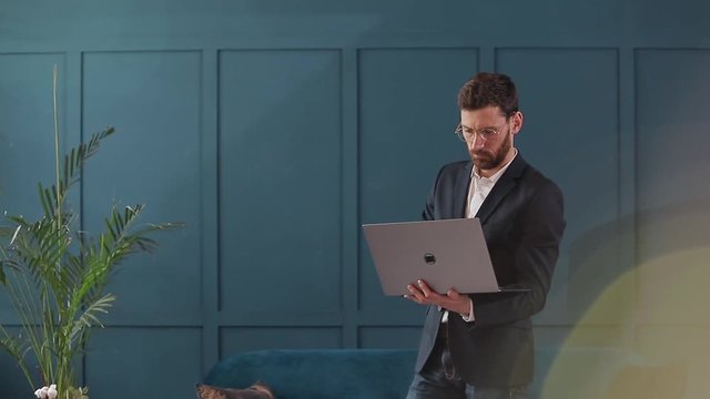 Portrait Of An Elegant Businessman With Laptop At The Luxury Blue Office Interior