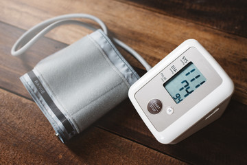 Sphygmomanometer an electronic blood pressure monitor on a wooden table. concept of health and...