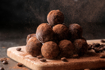 assorted chocolates. candy balls of different types of chocolate on a dark background. cocoa and coffee beans