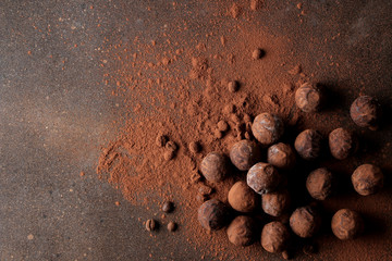 assorted chocolates. candy balls of different types of chocolate on a dark background. cocoa and...