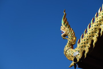 Fototapeta na wymiar Dragon sur le toit d'une pagode, ciel bleu