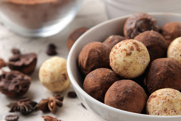 assorted chocolates. Candy balls of different types of chocolate on a light concrete background. cocoa, star anise and coffee beans