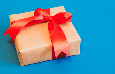 box with red ribbon and bow on blue background