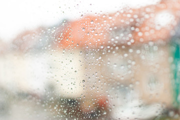Water drops on clean bright window focused detail in the city