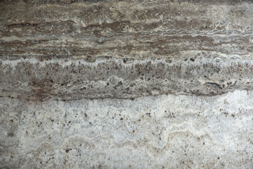 Obraz na płótnie Canvas Natural stone travertine gray-beige with parallel stripes is called Travertino Titanium