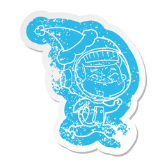 happy cartoon distressed sticker of a astronaut wearing santa hat