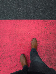 red marking on pavement with leather boot