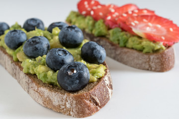 Healthy breakfast with blueberries and strawberries on unleavened avocado bread.