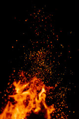 Fototapeta na wymiar Flame of fire with sparks in the air over a dark night