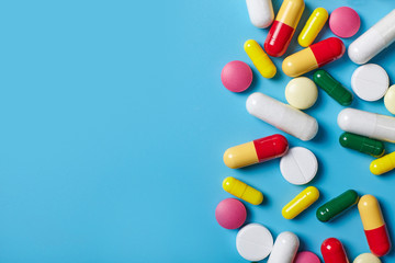Colorful pills on blue background. Top view.
