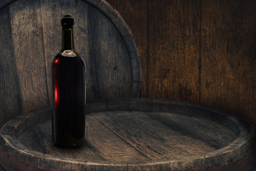 Red wine bottle on a old barrel table background wood wall.