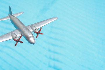 Naklejka premium Toy plane flys high above for travel and transport concept with blue sky
