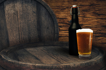 Wooden barrel and glass of beer on a old oak table of wood.