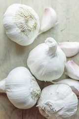 Garlic bulbs and cloves placed on natural, wooden background.