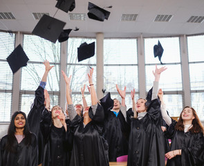 Multi ethnic group of graduated students throwing hats