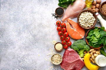 Fototapeta na wymiar Assortment of healthy protein sources and body building food : meat, fish, fruits, vegetables, legumes, nuts, cereals and dairy products.Top view with copy space.