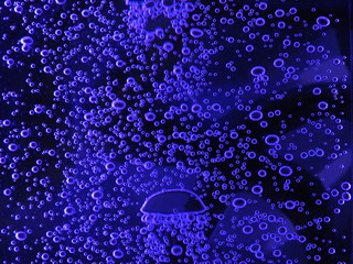 Close - up of air bubbles of different colors, in water isolated on dark background