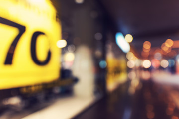 70% SALE sign blurred inside shopping center building with bokeh light background, interior and mall background