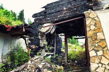 Burnt out house with charred roof trusses and burnt furniture