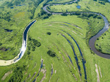 Aerial landscape of winding river in green fields