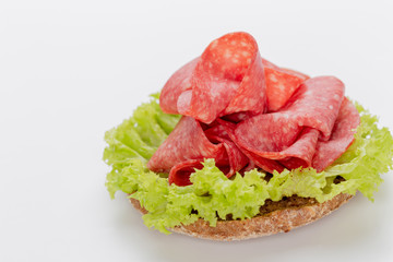 Sandwich with salami sausage on white background.