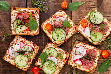 Sandwiches with cream cheese, vegetables and salami.