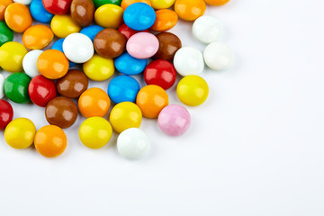 colorful candy on white background. Rainbow sprinkles for topping ice cream and cake. Small candies in colored chocolate glaze.