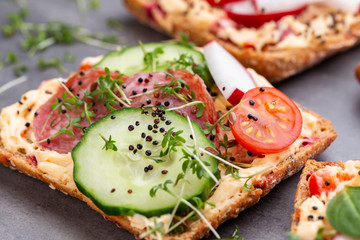 Sandwiches with cream cheese, vegetables and salami.