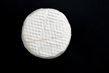 Brie cheese on a dark background