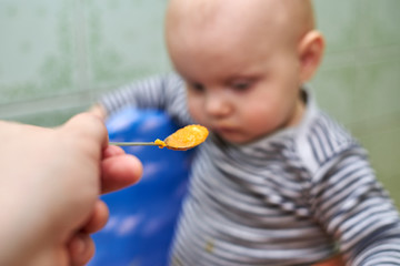 A boy with a closed mouth does not want to eat
