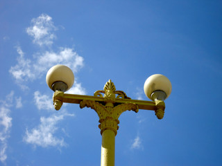 Old beautiful yellow lantern on a background of blue sky daytime summer park