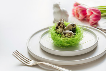 Easter table setting with pink tulip on white. Spring romantic dinner. Space for your text.