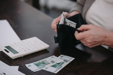 cropped view of senior woman holding wallet with money
