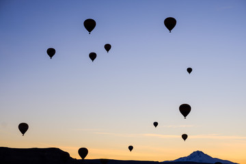 Silhouttes of hot air balloons in Cappadocia, Turkey, during sunrise